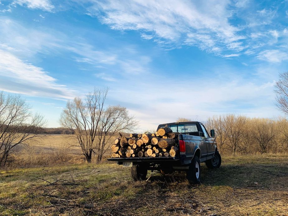 pickup truck hauling firewood in an open field